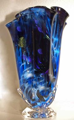 a blue glass vase sitting on top of a table