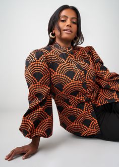 Style#: 2115/ P2115 Meet the Kari blouse with beautiful puff sleeves and button-up front in our Black Amber Dots African-inspired print. Easy to dress up or down, this blouse is a great addition to any fall wardrobe. Features: Mandarin Collar Puff Sleeve Elastic at the sleeve 97% Cotton/3% Spandex Stretch Poplin​ Designed in the USA, imported Care Instructions: Machine wash cold on a gentle cycle with non-chlorine detergent. Do not bleach. Hang to dry. Iron on low setting. Models: Size: XS Heigh African Print Blouse, Mens Fall, African Inspired, Print Blouse, Blouse Black, Printed Bags, Workout Accessories, Fall Wardrobe, Swimwear Accessories