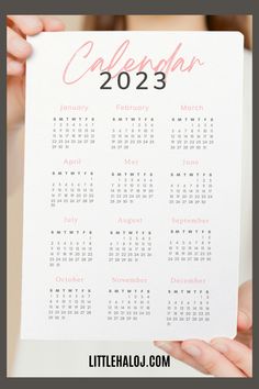 a woman holding up a calendar for the year 2013 to 2013 with pink ink on it