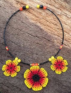 My flower choker is definitely for a Boho girl or lady, who has a love for bright and sunny colours and nature. What better way to add some sunshine to your life than with this lightweight piece?  Repurposed beaded flowers.  Repurposed wooden yellow beads. Repurposed black and orange plastic crystals. Repurposed small plastic orange and yellow beads. Repurposed black glass seed beads. New silver plated memory wire. New silver plated jump rings. Approximately 15.5cm long. Central flower approxima Yellow Choker Necklace As A Gift, Adjustable Handmade Beaded Necklaces, Yellow Choker Necklace For Gift, Hippie Jewelry With Tiny Beads For Gifting, Adjustable Yellow Flower Necklace, Yellow Adjustable Flower Pendant Necklace, Hippie Jewelry With Tiny Beads For Gift, Adjustable Yellow Flower Pendant Necklace, Festival Beaded Choker Necklace Gift