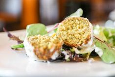 a white plate topped with meatballs and greens