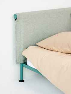 an upholstered headboard with two pillows on the bottom and one in the middle