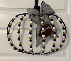 a door hanger decorated with beads and a football