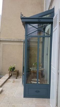 a small patio with a table and chairs next to a door on the side of a building