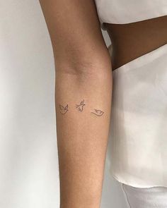 a woman's arm with two birds on it and one bird in the middle