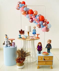 there are many balloons on the table and toys in front of it, as well as other decorations