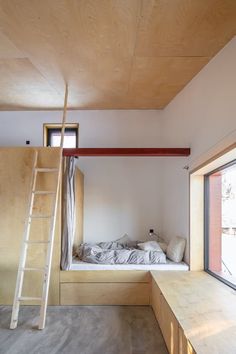 there is a bunk bed in the middle of this room with a ladder hanging from the ceiling