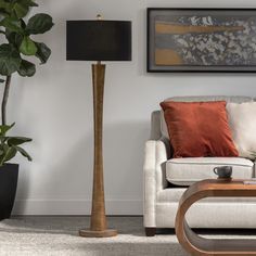 a living room scene with focus on the floor lamp and couch in the foreground