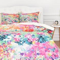 a bed with colorful sheets and pillows on top of it