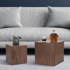 two wooden tables sitting next to each other in front of a couch with pillows on it