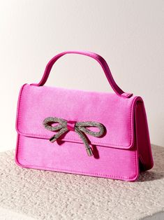 Add a trendy, feminine touch to every outfit with your new favorite bag from Shiraleah - the Bowie Mini Bag. This petite, rectangular purse is made from a sleek satin fabric in a vibrant pink color and features an adorable top handle with a snap closure. The front of the purse is adorned with a sparkling silver bow detail which is sure to turn heads this winter season. Pair with the matching Satin Knotted Headband or other items from Shiraleah to complete your look! Shiraleah is a trend-driven l One Piece Clothing, Accessories Display, Knotted Headband, Silver Bow, Framed Gifts, Zip Pouch, Knot Headband, Pouch Bag, Scarf Hairstyles