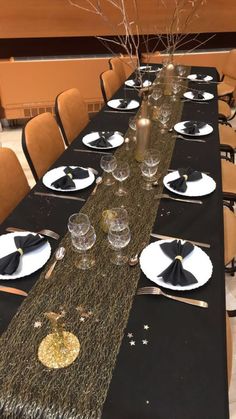 the table is set with black and white plates, napkins, and silverware