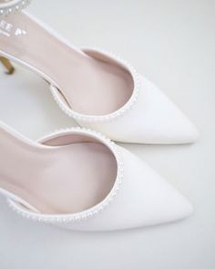 Classic satin pointy toe heels with an added touch for romantic, elegant and feminine look. The prettiest pearl details on this elegant satin heel checks off all the right boxes. The delicate mini pearl beads are placed carefully by hand to create a graceful classic bridal shoe. Perfect for brides, bridal party, bridesmaids, prom, parties, or any special occasion. DETAILS: HEELS: 3 inches COLORS AVAILABLE: Ivory and White UPPER: Synthetic upper and lining MATERIALS: Manmade outsole ORIGIN: Imported STYLE NAME: BELL Pearl Wedding Heels, Formal Heels, Bridal Shoe, Pearls Wedding, White High Heels, Pointy Toe Heels, Pearl Details, Satin Heels, Pointed Heels