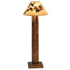 a lamp that is sitting on top of a wooden stand with leaves painted on it