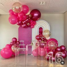 pink and gold balloons are hanging from the ceiling