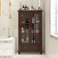 a bathroom with marble flooring and white walls, including a glass door cabinet in the center