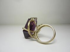 "This completely unique and one of a kind ring was purchased from the estate of a jewelry designer who made many custom and unique pieces in our local area around Cleveland, Ohio in the 70's and 80's. The 14k gold setting features a split ring shank and gold leaves that circle around and beneath the gigantic gemstone. The gemstone is a violet-blue to purple color-change sapphire in a free form cut. Gemstone Dimensions - 27mm x 18mm x 9.5mm Ring Size 5.5. (Can easily be resized to most sizes) Mar Modern Yellow Gold Collectible Rings, Modernist 14k Gold Ring Jewelry, Modernist Hallmarked 14k Gold Jewelry, Unique Yellow Gold Amethyst Ring, Modernist 14k Gold Wedding Jewelry, Modern 14k Gold Collectible Jewelry, Modern Handmade 14k Gold Rings, Collectible Modern 14k Gold Jewelry, Unique 14k Gold Rings With Polished Finish