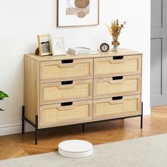 a wooden dresser with drawers and pictures on the top shelf next to a white rug