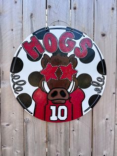 a sign on the side of a wooden fence that says hogs with a cow's head