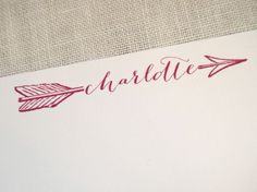 the name charlotte written in red ink on a white envelope with an arrow drawn on it