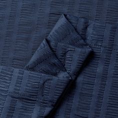 an image of a blue quilted bedding with two pillows on the bottom and one pillow in the middle