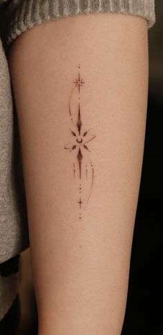 a woman's arm with a cross tattoo on the left side of her leg