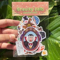 a hand holding up a sticker with an image of a clown in the center