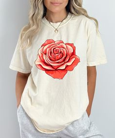 Add a touch of elegance to your wardrobe with this stunning floral design shirt featuring a vibrant red rose. Perfect for those who love nature-inspired fashion, this flower graphic tee is both stylish and versatile, making it a great choice for casual outings or dressing up with accessories. Crafted from high-quality, soft fabric, this botanical print t-shirt ensures comfort and durability. The bold rose design stands out beautifully against the black background, making it a statement piece that's sure to draw compliments. Whether you're a plant lover, a fan of floral patterns, or simply looking for a unique gift for her, this floral t-shirt for women is a perfect addition to any wardrobe. Key Features: Premium Quality: Made from soft, breathable fabric for all-day comfort. Vibrant Design Summer Graphic Tee With Rose Print, Trendy Rose Print T-shirt For Spring, Rose Print Tops For Summer, Spring Graphic Tee With Rose Print, Spring Rose Print Graphic Tee, Summer Short Sleeve T-shirt With Rose Print, Spring Rose Print Short Sleeve T-shirt, Summer Rose Print Short Sleeve T-shirt, Spring Cotton T-shirt With Rose Print