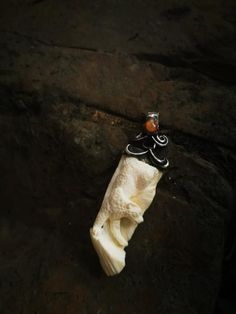 a toothbrush holder sitting on top of a rock next to a piece of paper