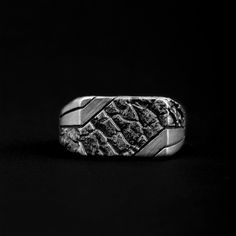 a silver ring sitting on top of a black surface