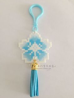 a key chain with a cross on it and a tassel hanging from the end