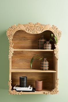 a wooden shelf with two shelves on top of it and some plants in the corner