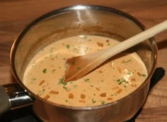 a wooden spoon in a pot filled with soup