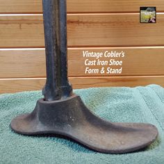 an old cast iron shoe on a blue towel with the words vintage cobble's cast iron shoe form & stand