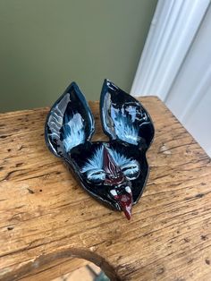 two decorative blue and white dishes sitting on top of a wooden table