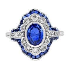 Charming Art Deco style engagement ring featuring a 1.6 carat (approx) Ceylon sapphire center surrounded by total of .45 diamonds and French cut sapphire in 18k white gold. The milgrain adds to the vintage style. This beautiful piece would make the perfect engagement or dress ring. Ring Information Style: Art-deco Metal: 18K White Gold Total weight: 4.70 g. (approx. total weight) Ring size: US 3 – 8 available Center Gemstones Type: Ceylon Sapphire Shape: Oval Cut Size: 8 x 6 mm. Number: 1 Weight Luxury Art Deco Sapphire Ring, Art Deco Sapphire Ring With Vvs Clarity, Art Deco Platinum Sapphire Ring With Brilliant Cut, Luxury Art Deco Emerald-cut Sapphire Ring, Collectible Art Deco Platinum Sapphire Ring, Art Deco Sapphire Ring, Shiny Rings, French Cut, Ceylon Sapphire