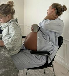 a pregnant woman sitting in an office chair with her baby bumping on her stomach