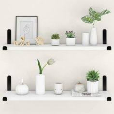 two white shelves with plants and candles on them