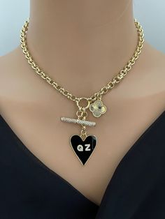 This beautiful personalized black enamel heart charm necklace is perfect for layering. The clover charm and CZ toggle charm dazzle the neckline. Please enter your choice of 2 initials in the message section of your order. Multi charm personalized necklace features three layered gold plated charms: 1. Black enamel heart charm2. Gold detailed clover charm3. CZ encrusted toggle bar4. Two initials of your choosing in CZ Chunky gold rolo chain sturdy 18k electroplated over brass.Lobster Closure. Tips Clean Packaging, Hand Knotted Necklace, Heart Charm Necklace, Clover Charm, Gold Necklace Designs, Knot Necklace, Rolo Chain, Coin Necklace, Keep Jewelry