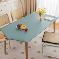 there is a bowl of fruit on the table with two chairs in front of it