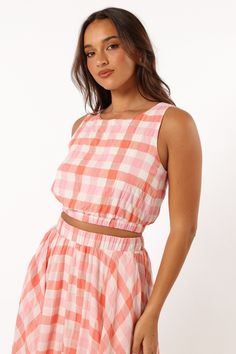 DETAILS   Our Betty Top is the perfect go-to for any sunny day. It features a cropped length, non adjustable straps and an elasticised waistband to keep you stylish and comfortable all day long. With a pink gingham print design to make you stand out from the crowd.   cropped length  round neckline  non adjustable straps  elasticised waistband  gingham print  lined  m aterial - 100% cotton / lining - 100% rayon     SIZING      studio model is 5' 7" and wears a Size S    model stats: bust - 33", w Spring Crop Top For Picnic, Spring Picnic Cropped Top, Casual Gingham Cotton Crop Top, Casual Gingham Crop Top For Spring, Sleeveless Crop Top With Elastic Waistband For Spring, Spring Beach Crop Top With Elastic Waistband, Pink Crop Top With Adjustable Straps, Gingham Cropped Top For Summer, Spring Cotton Crop Top With Elastic Waistband