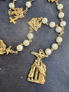 White beads with golden cross stations of the cross rosary Gold Rosary Bracelet With Cross And 8mm Beads, White Crucifix Cross Necklace, White Spiritual Crucifix Cross Necklace, Gold Spiritual Rosary With Miraculous Medal, Spiritual Gold Rosary With 8mm Beads, White Spiritual Cross Jewelry And Charms, Gold Necklaces With 8mm Beads For Blessing, Gold Cross Rosary Spiritual, Gold Cross Rosary In Spiritual Style