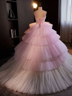 a pink dress is displayed on a mannequin in front of a bookcase