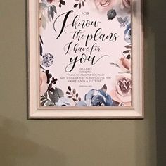 a framed poster hanging on the wall above a toilet in a bathroom with a pink and blue floral design