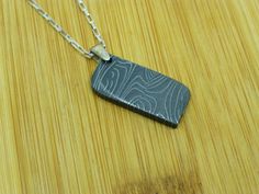 We are bringing you a touch of heaven for your self or that person in your life! This Pendant was made out of Meteorite Damascus steel. It contains 40 % Gibeon Iron meteorite and High Carbon tool steel. Gibeon Iron meteorite came from one of the largest iron meteorite finds in Namibia, Africa. This very beautiful and unusual meteorite was first found in 1836, although native inhabitants knew about it before then. Most specimens show flight markings and evidence of a violent atmospheric breakup. Rectangular Etched Jewelry For Gifts, Black Etched Jewelry For Gifts, Black Etched Jewelry For Gift, Meteor Jewelry, Touch Of Heaven, Namibia Africa, Meteorite Jewelry, 6th Anniversary Gifts, Space Rocks