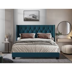 a bed with blue upholstered headboard and pillows on top of the bed