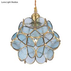 a light fixture with blue glass petals hanging from it's brass finish metal holder