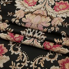 the fabric is black with pink and gold flowers on it, as well as an intricate design