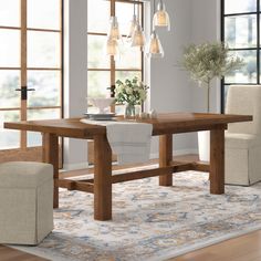 a dining room table and chairs in front of windows