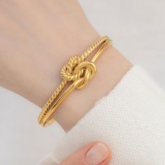 "Title: Knot Cuff Bracelet Product Description: Materials: High Quality Stainless Steel Finish: 18k Gold plated Size Specs: * The dimensions of the bracelet is apx. 6.5\", it can comfortably fit wrists ranging from 5\" to 7\". How To Order:   1- Explore our Collection   2- Select Your Favorites: Once you've found your favorite pieces, click on the product to view detailed information. Select your preferred options, such as metal /material type, gemstone, size, chain type , chain length etc.    3- Add to Cart: Hit the \"Add to Cart\" button to secure your chosen items. You can continue shopping or proceed to checkout when you're ready.   4- Review Your Order: Double-check your order in the shopping cart to ensure you have the right items and specifications. Make any necessary adjustments be Adjustable Tarnish Resistant Bracelets For Mother's Day, Adjustable Gold-plated Bracelet For Anniversary, Adjustable Gold Plated Bracelet For Anniversary, Adjustable Bangle Bracelet For Promise, Gold Bangle Bracelets For Promise, Tarnish Resistant Adjustable Bracelets For Anniversary, Adjustable Tarnish Resistant Bracelets For Anniversary, Adjustable Jubilee Bracelet Bangle For Anniversary, Gold Plated Bracelets For Anniversary On Mother's Day